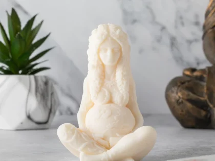 A beautifully detailed Earth Goddess Candle, depicting a seated goddess figure, available in various colors.